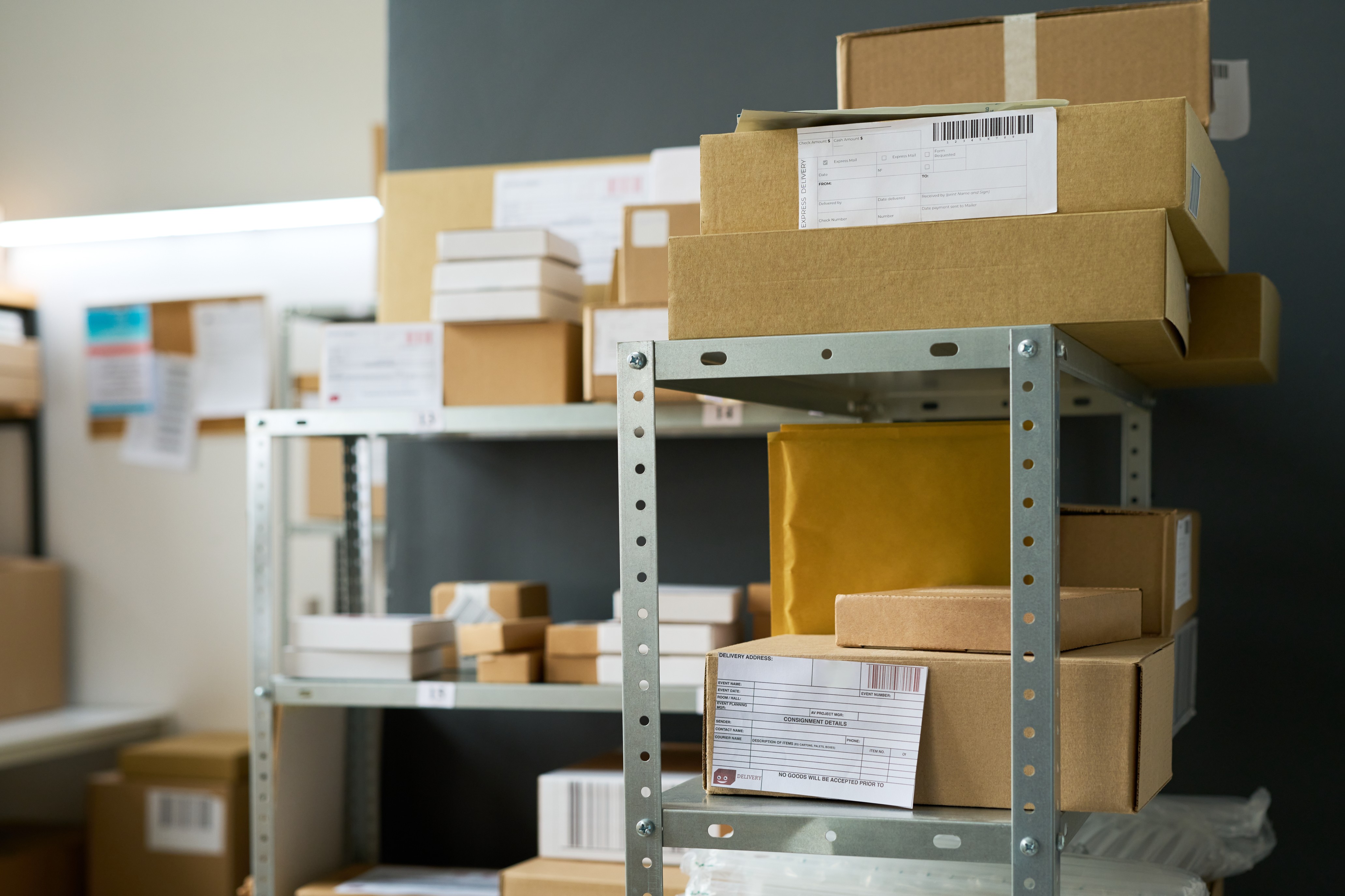 Packages organized on metal shelving in a secure mailroom